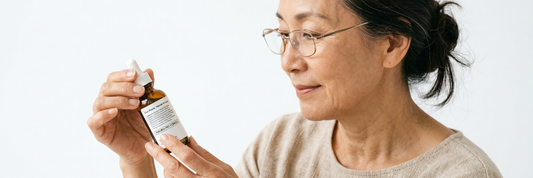 Mature woman reading ingredient label on skincare bottle representing paraben-free cosmetic choices